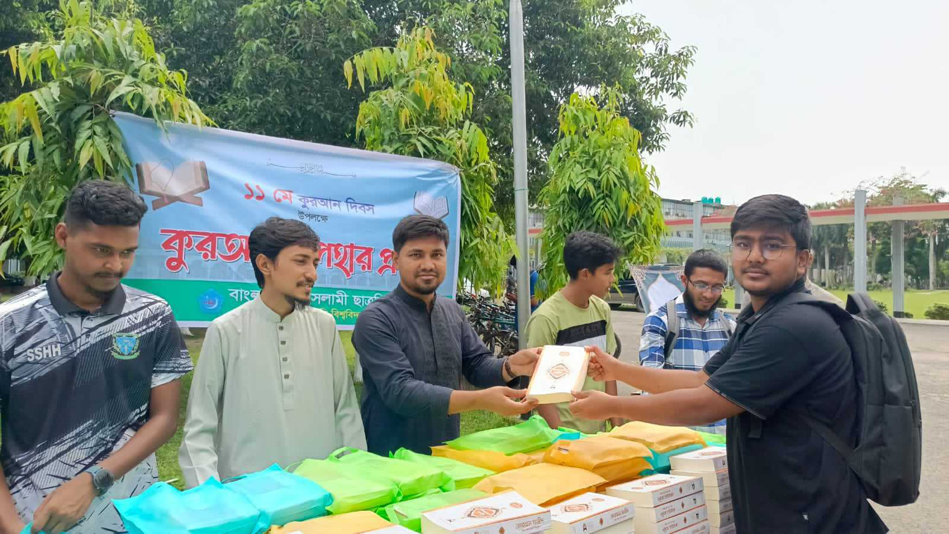 বিশ্ববিদ্যালয়ের কেন্দ্রীয় গ্রন্থাগার ভবনের সামনে কোরআন বিতরণ করা হয়। ছবি: সময় সংবাদ