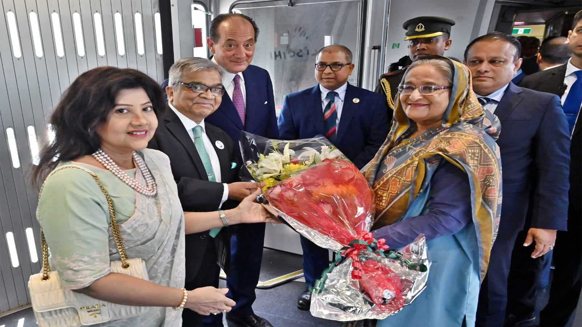 প্রধানমন্ত্রী শেখ হাসিনা ইতালি পৌঁছালে সেখানে নিযুক্ত বাংলাদেশের রাষ্টদূত মো. শামীম আহসান এবং ইতালির দূত উবার্তো ভ্যানি ডি আর্চিরাফি তাকে ফুল দিয়ে স্বাগত জানান। ছবি: সংগৃহীত
